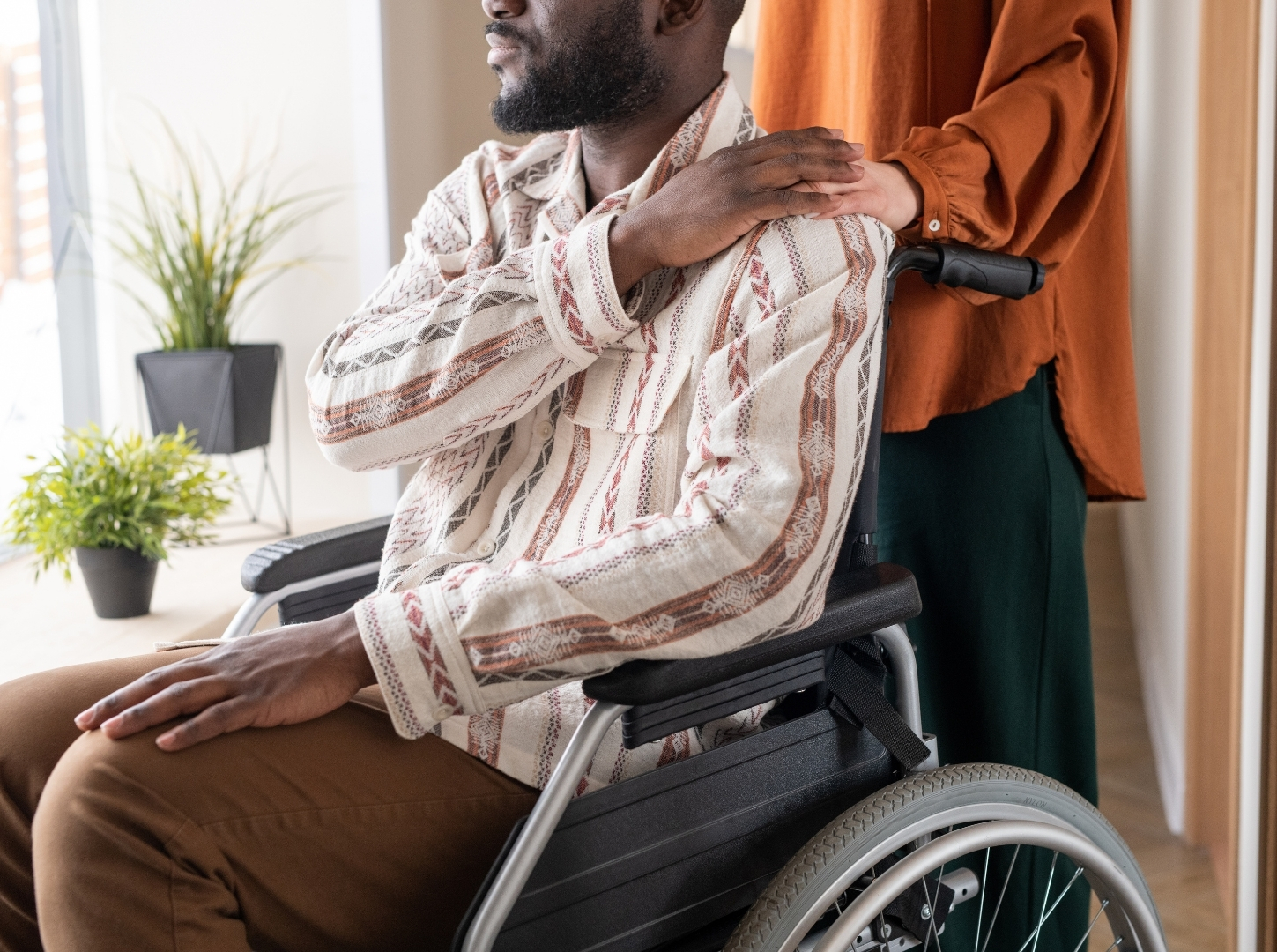 Side View of Man with Disability Keeping His Hand on That of Female Caregiver